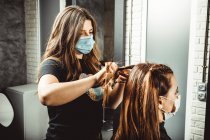 Esteticista e cabeleireiro trabalhando com máscara para o vírus covid19 — Fotografia de Stock