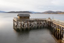 Casa no porto de madeira em um fiorde norueguês — Fotografia de Stock