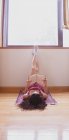 Junges Mädchen liest auf einem Teppich liegend mit den Füßen an der Wand — Stockfoto