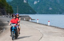 Young couple exploring Cat Ba Island on a motor scooter — Stock Photo