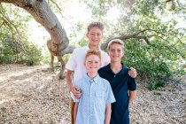 Porträt von drei Jungen, die unter dem Baldachin einer riesigen Eiche lächeln — Stockfoto