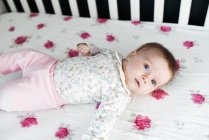 Little baby girl in her crib — Stock Photo