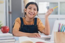 Щаслива азіатська дівчина вчить онлайн вдома — стокове фото
