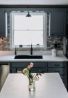 Bancada da cozinha branca com flores e vaso e janela no backgroun — Fotografia de Stock