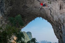 Homme grimpant l'arche à Moon Hill à Yangshuo — Photo de stock
