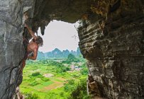 Young male climber climbing at treasure cave in Yangshuo, China — Stock Photo