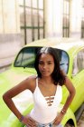 Young cuban in front an old car in havana — Stock Photo