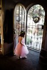 Menina de pé pela porta da frente vestindo tutu e coroa de flores — Fotografia de Stock