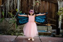 Милая маленькая девочка в костюме бабочки развлекается — стоковое фото