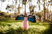 Bonito menina no borboleta traje ter diversão — Fotografia de Stock