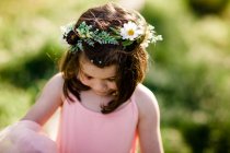 Милая маленькая горлица в цветочном венке, улыбающаяся на улице. — стоковое фото