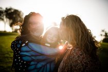 Aunt, uncle and niece hugging and posing during sunset — Stock Photo