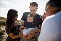 Família sorri como pai segura bebê — Fotografia de Stock