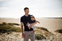 Pais jovens com menino na praia — Fotografia de Stock