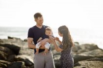 Giovani genitori con bambino sulla spiaggia — Foto stock
