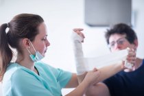 Krankenschwester macht einer Patientin Armbinden — Stockfoto