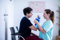 Nurse tigthing a armbracer to a patient female — Stock Photo