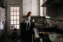 Молода дівчинка і хлопчик в псевдонімах і допомагають снідати на кухні — стокове фото
