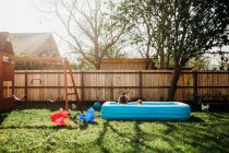 Two young kids swimming in the backyard pool — Stock Photo