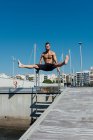 Sportivo che pratica stretching e calistenica nelle strade della sua città — Foto stock