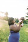 Мати з її новонародженою дитиною позує на відкритому повітрі — стокове фото