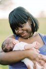 Мати з її новонародженою дитиною позує на відкритому повітрі — стокове фото