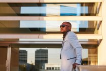 African-American man in a fancy suit enjoying the sunset outside the office. — Stock Photo