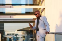African American businessman with mobile phone on a summer afternoon. — Stock Photo