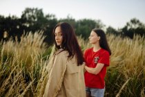 Two women standing in tall grass — Stock Photo