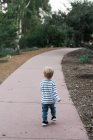 Um ano de idade menino andando ao longo de um caminho no parque Balboa em San Diego — Fotografia de Stock
