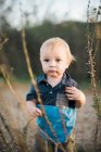 Little toddler boy playing with dried flowers — Stock Photo