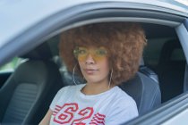 Frau mit Afrohaaren sitzt in ihrem Auto — Stockfoto