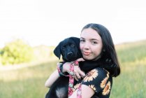 Schöne Mädchen mit niedlichen Labrador-Welpen im Freien — Stockfoto