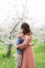 Une mère avec son fils dans un verger de pommiers en fleurs en Nouvelle-Angleterre — Photo de stock