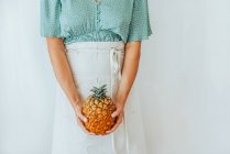 Портрет красивой молодой женщины, позирующей с ананасом — стоковое фото