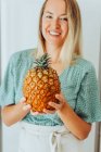Portrait of beautiful young woman posing with pineapple — Stock Photo