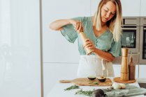 Junge Frau kocht gesundes Essen in Küche — Stockfoto