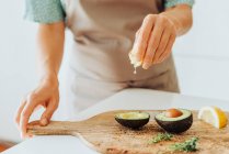 Обрізаний знімок жінки готує авокадо для їжі — стокове фото