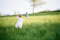 Una fotografia analogica di bambine che corrono verso un albero — Foto stock