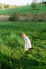 Retrato de una niña explorando un campo - foto de stock