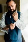 Porträt eines Mannes im Anzug, der sich vorbereitet und seinen Manschettenknöpf fixiert — Stockfoto