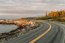 Schöne Herbstlandschaft. Straße mit gelben und grünen Bäumen im Hintergrund — Stockfoto