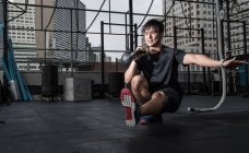 Man training with kettle bell at rooftop gym in Bangkok — Stock Photo