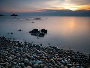 Скелясте узбережжя моря з заходом сонця — стокове фото