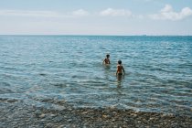 Dos chicos vadeando en el lago Ontario en un día de verano. - foto de stock