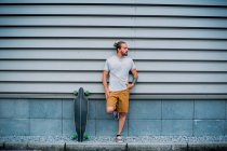 Молодий красивий чоловік зі скейтбордом на відкритому повітрі — стокове фото