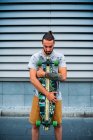 Junger schöner Mann mit Skateboard im Freien — Stockfoto