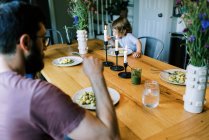 Una giovane famiglia che si gode una cena insieme al pesto fatto in casa — Foto stock