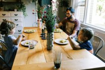 Молодая семья наслаждается ужином вместе со своим домашним песто — стоковое фото