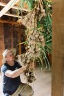 Un uomo che elabora il suo raccolto di aglio e si prepara ad asciugarlo — Foto stock